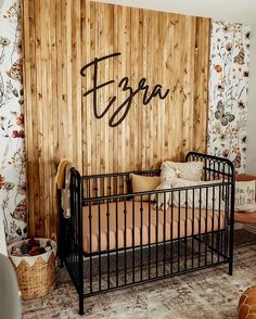 a baby's crib in front of a wooden wall with the word ega written on it