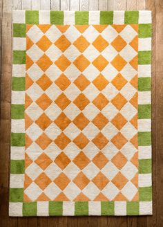 an orange and green rug on a wooden floor