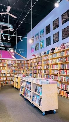 the inside of a book store with many books on shelves and ceiling fans hanging from the ceiling