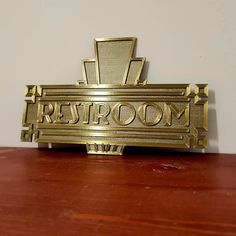 a gold sign that says restroom on it