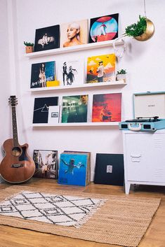 there is a guitar and other items on the floor in front of a white wall