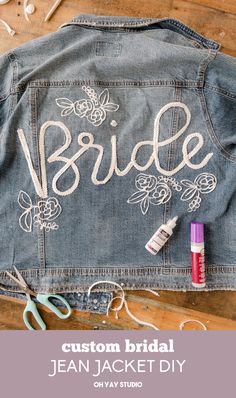 a jean jacket with the word bride painted on it and scissors next to it, along with other items