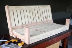 a bench made out of wood sitting on top of a wooden table next to tools