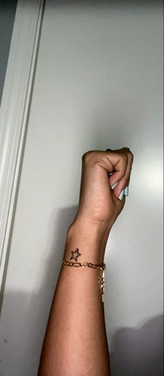 a person's arm with a star on it and a chain around the wrist