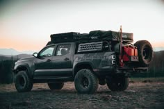 the truck is parked on the side of the road in the wilderness with its roof down