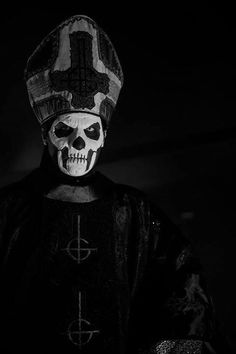 a skeleton wearing a hat and cross on it's head in black and white