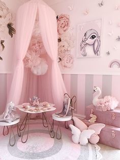 a room with pink furniture and flowers on the wall, including a canopy bed in the corner