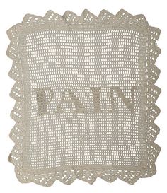 an embroidered pillow with the word love in white letters on it and scalloped edges