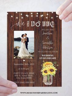 a wedding announcement with sunflowers and mason jars on the front is held up by two hands