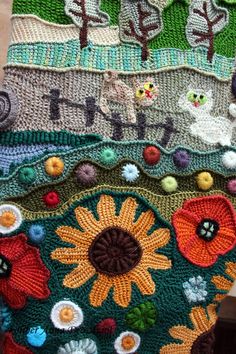 there is a crocheted blanket with flowers and cats on it