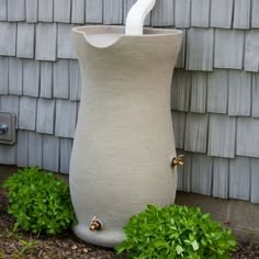 a large white vase sitting next to a house