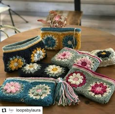 several crocheted purses sitting on top of a wooden table