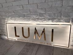 the lumi aesthetics and infectatable bar sign is on display against a brick wall