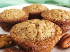 several muffins and pecans on a white plate