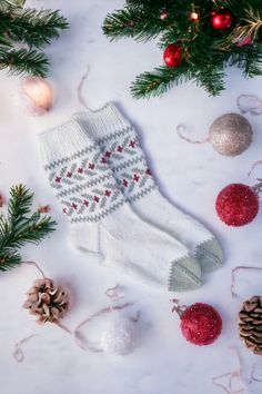 a pair of white socks sitting on top of a table next to christmas decorations