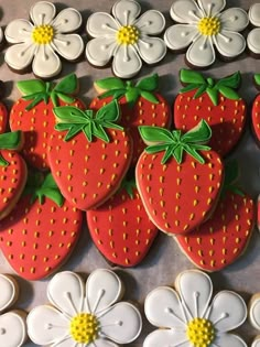 decorated cookies with strawberries and flowers on a table