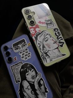 two cell phones with stickers on them sitting next to each other