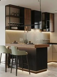 a modern kitchen with bar stools next to the counter and wine glasses on it