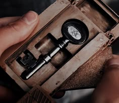 a person is holding an old wooden box with a telescope in it's case