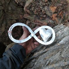 someone is holding an origami piece in their hand on top of a rock