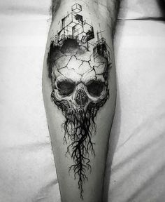 a man's leg with a skull and tree roots on it