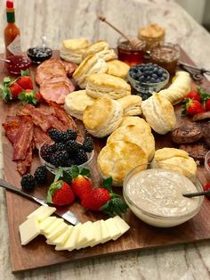 a wooden cutting board topped with different types of food and condiments on top of it