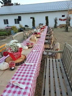 a long table is set up outside with red and white checkered cloth on it