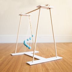 two swings with balls hanging from them on the floor