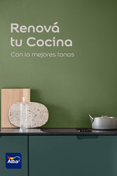 a kitchen with green walls and white lettering on the wall, next to a potted plant