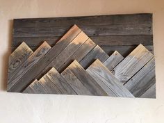 a wooden wall hanging on the side of a building with wood planks in it