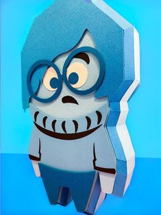 an origami character with glasses and a blue cap is standing in front of a blue background