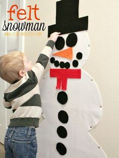 a young boy making a snowman out of felt