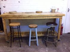 three stools sitting under a wooden table