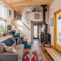 a living room filled with furniture and a fire place next to a window on top of a wooden floor