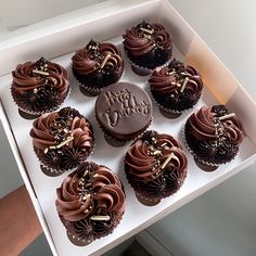 twelve chocolate cupcakes in a white box with happy birthday written on the top