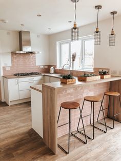 a kitchen with two bar stools next to an island