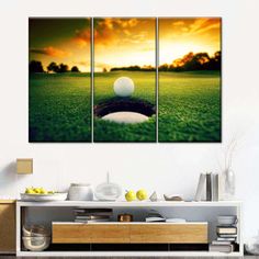 a golf ball sitting on top of a green field with the sun setting behind it