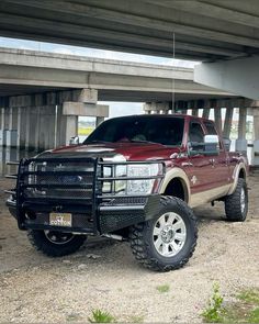 a red pick up truck parked under a bridge