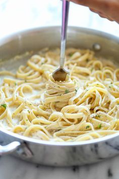 someone is stirring some noodles in a pan