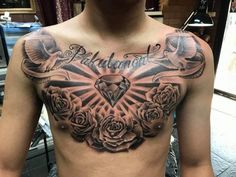 a man's chest with tattoos and roses on it