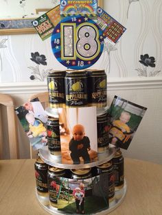 a birthday cake made out of beer cans with pictures on the top and bottom tier