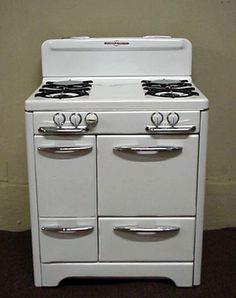 an old fashioned white stove with four burners and two oven doors on each side