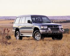 a silver suv parked in the middle of a field