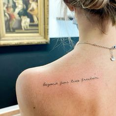 the back of a woman's neck with a tattoo that reads, beyond your own passion