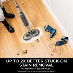 a person vacuuming wood floors with the words up to 2x better stuck - on stain removal