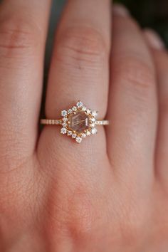 a woman's hand with a diamond ring on top of her finger and an engagement band