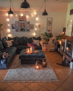 a living room filled with lots of furniture and lights on the wall above it's fireplace