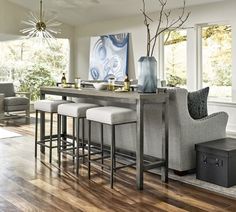 a kitchen island with stools in front of it and a painting on the wall