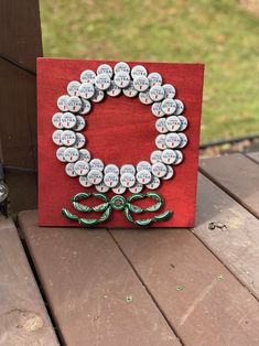 a bottle cap wreath on a red canvas