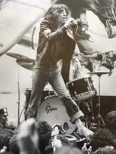 a man standing on top of a stage next to a drum